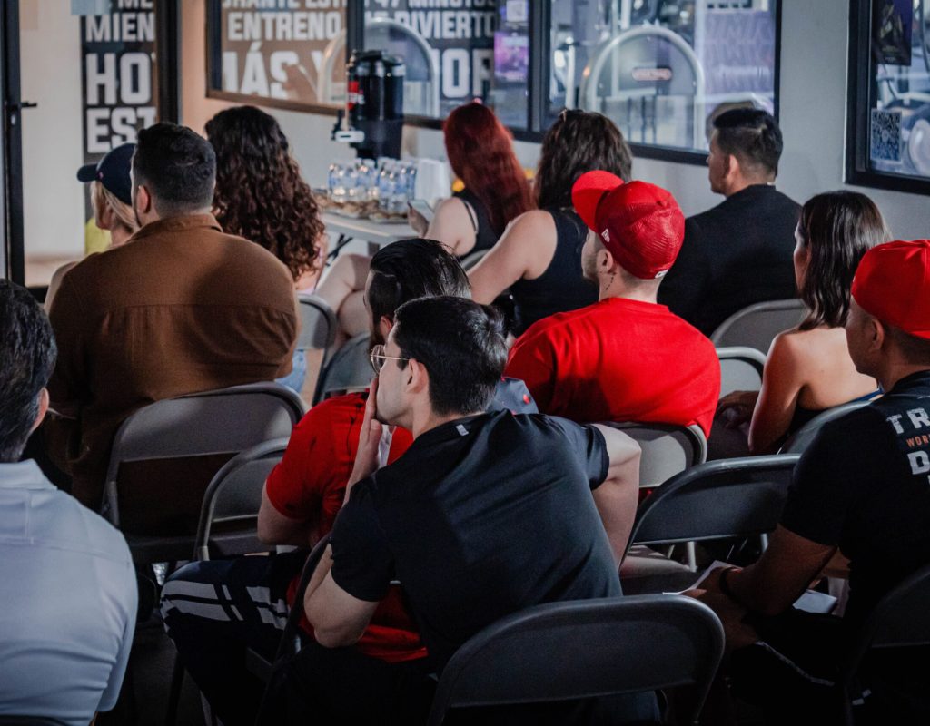 A diverse audience attentively participates in an indoor seminar setting, highlighting education and engagement.