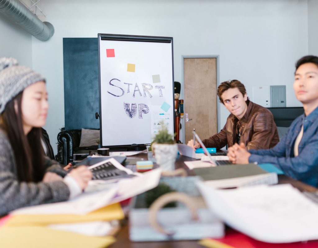 A group of young professionals brainstorming ideas in a startup office setting.